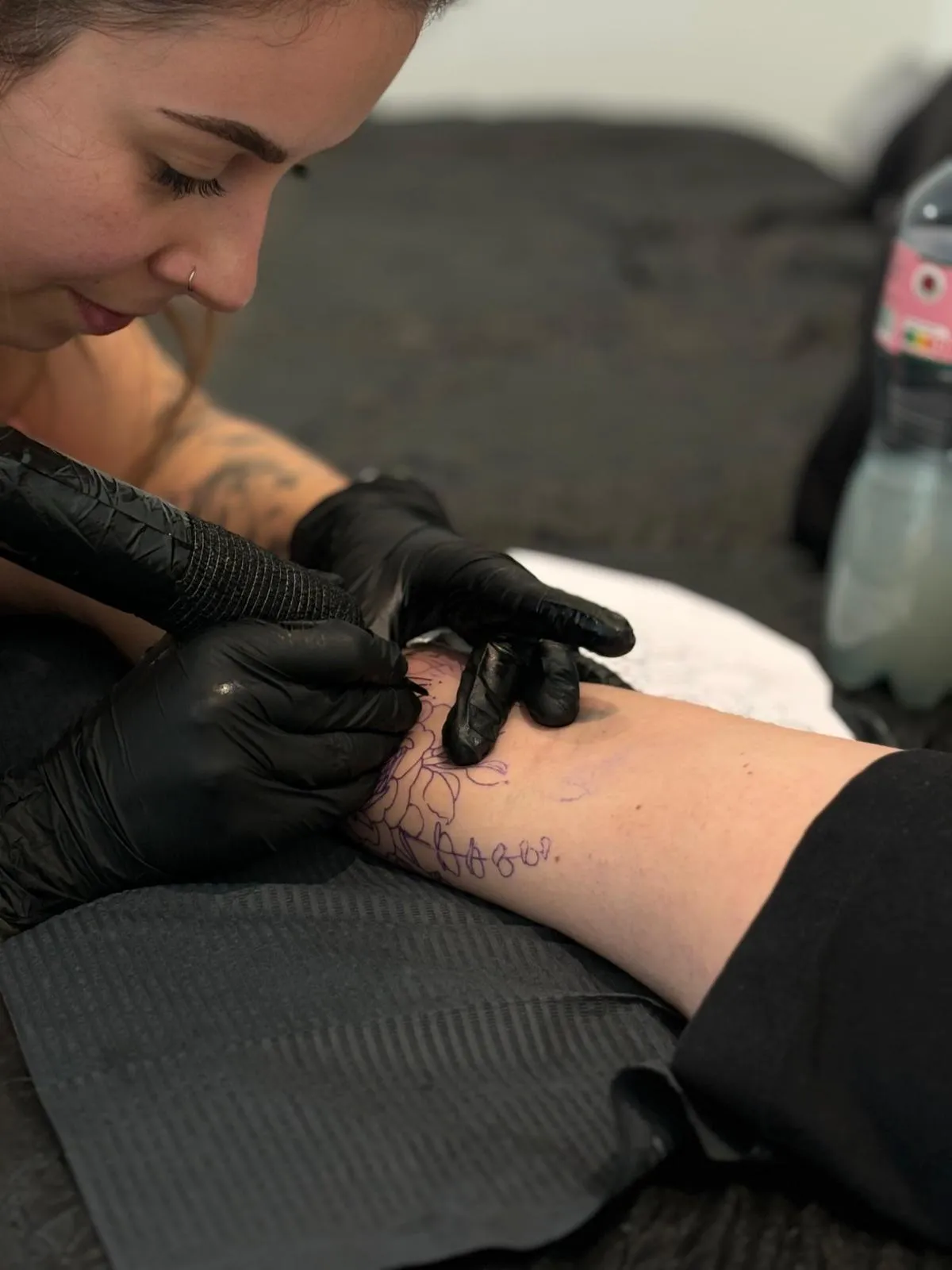 Naomé tatouant dans son studio.